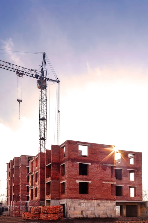 tower-crane-near-brick-construction-building_446232-552